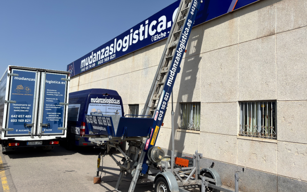 Grúa para mudanzas en Alicante y Elche, vehículo con pluma elevando un mueble por un balcón en una mudanza con acceso difícil